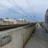 Strada Zuccararo incontra i binari e devia verso destra costeggiata da un muretto